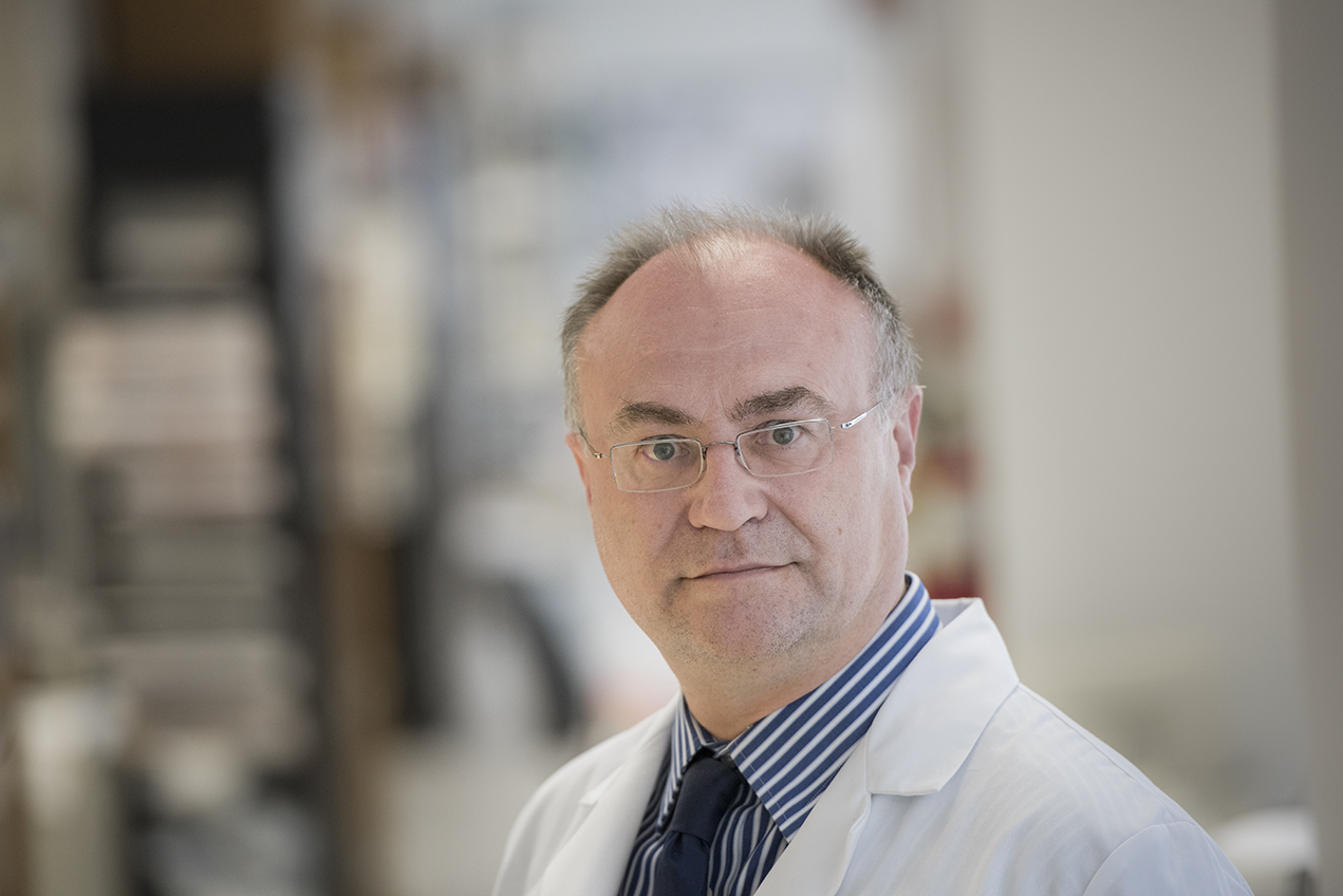 A portrait features a bespectacled doctor